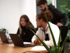 drei Mitarbeitende eines IT-Unternehmens, die am Laptop arbeiten